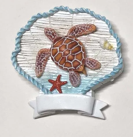 Scallop-shell resin souvenir magnet with a sea turtle and starfish and a blank ribbon banner.