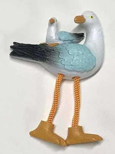 Resin souvenir magnet of a single seagull with dangling rope legs and painted feet.